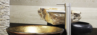 Goldenes Waschbecken, umringt von Fliesen in Steinoptik